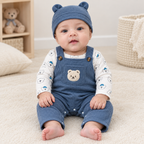 Sara wearing blue bear dungarees and matching hat with bare feet