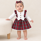 Sara standing with support in a white ribbed and red plaid lace-trim dress with matching bow headband